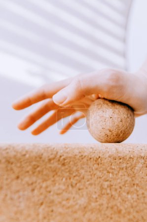Close up of hand doing palm fascia release exercise with cork ball