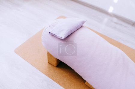 Close up bolster, blocks and eye pillow - props setting for relaxing yin, restorative yoga