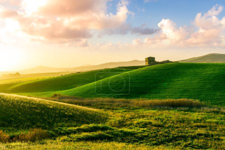 Téléchargez les photos : Paysage vue rurale d'une ferme de campagne dans les champs verts et les collines avec un ciel nuageux incroyable en arrière-plan - en image libre de droit