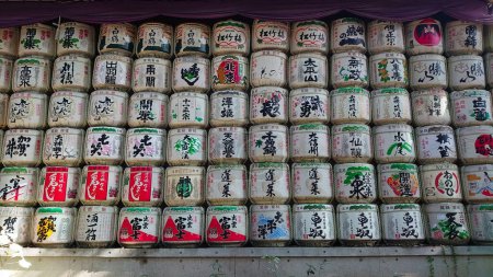Téléchargez les photos : Tokyo, Japon - 10.26.2019 : Un mur de barriques de saké, vin de riz japonais, exposé le long de l'approche sud du sanctuaire Meiji avant la pandémie - en image libre de droit