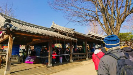Photo for Nami seom, Seoul, South Korea - Feb 5, 2019: passengers waiting to board the ferry on the tile roof covered pier to go to Namiseom Island - Royalty Free Image