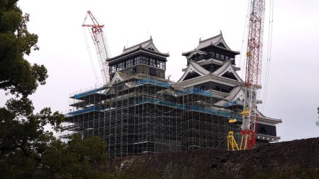 Téléchargez les photos : Kumamoto, Japon - 26.01.2020 : L'arrière du château de Kumamoto en reconstruction après le tremblement de terre de 2016 avec des échafaudages et une grue en vue sous un ciel nuageux - en image libre de droit