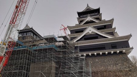 Téléchargez les photos : Kumamoto, Japon - 01.26.2020 : Château de Kumamoto en reconstruction après le tremblement de terre de 2016 avec échafaudages et grue en vue sous un ciel nuageux - en image libre de droit