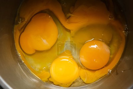 Photo for Eggs broken in the toe, yolk and white, preparation and baking process - Royalty Free Image