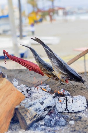 Foto de Pescado cocinando sobre las brasas en la playa al mediodía. - Imagen libre de derechos