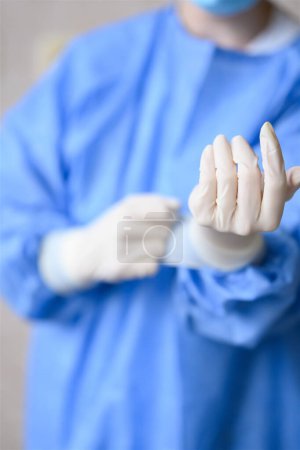 Nurse puts on white nitrile surgical gloves. High quality photo