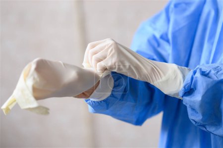 Krankenschwester zieht weiße Nitril-OP-Handschuhe an. Hochwertiges Foto