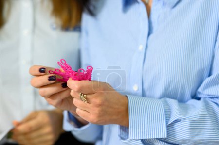Die Hand der Frau hält die kieferorthopädische Separator-Elastomerligatur. Hochwertiges Foto
