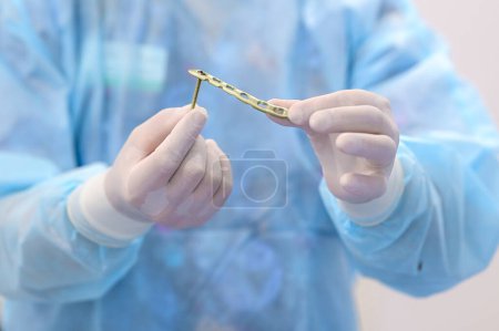 Arzt wählt orthopädische Schrauben und Bolzen für die Operation. Nahaufnahme.Hochwertiges Foto