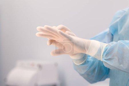 Krankenschwester oder Arzt ziehen weiße Nitril-OP-Handschuhe an. Hochwertiges Foto