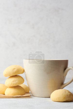 Photo for Ghee biscuits or cookies on table with a tea cup, against blurry white textured background, homemade melt in mouth nei biscuits, eggless cookies are made whole wheat flour, selective focus, copy space - Royalty Free Image