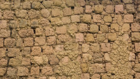 Foto de Sección de una antigua superficie de pared de ladrillo sin cocer, también conocida como pared de ladrillo de arcilla secada al sol, edificios de barro utilizados ampliamente en muchas áreas remotas, fondo abstracto - Imagen libre de derechos