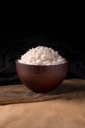Schüssel mit gekochtem weißen Reis, auf einer hölzernen Tischplatte, serviert Essen Nahaufnahme Ansicht mit Kopierraum