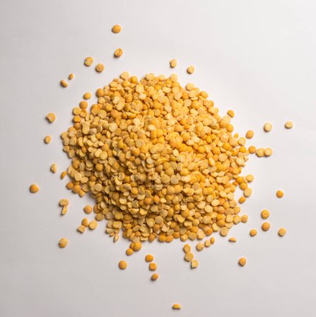 Foto de Montón de guisantes divididos amarillos, semillas secas, peladas y partidas de guisantes, aisladas sobre un fondo gris neutro, tomadas desde arriba - Imagen libre de derechos
