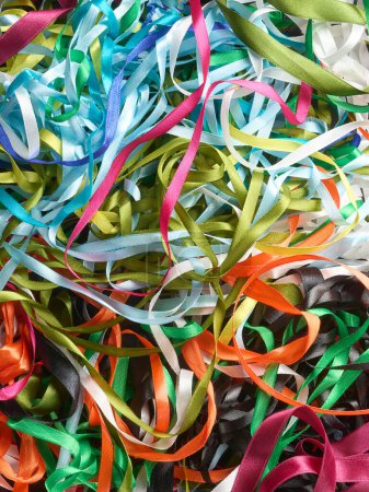 bunch of tangled colorful textile satin ribbons, full frame background abstract, taken straight from above