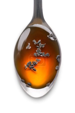Foto de Cucharada de miel con semillas negras, también conocido como comino negro o alcaravea o kalonji, aislado sobre fondo blanco, macro de primer plano - Imagen libre de derechos