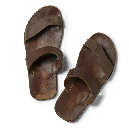 pair of old used sandals isolated white background, dirty worn-out soles and faded straps taken straight from above