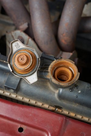 close-up of old rusty muddy car radiator cap, rust buildup on vehicle radiator, issues in car cooling system like overheating and corrosion, safety maintenance concept, selective focus with copy space