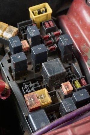 Photo for Fuse box, panel or block in a car, located in engine compartment, protect vehicle electrical components from damage cause by faults, selective focus with blurry background and vertical orientation - Royalty Free Image