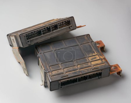 old and used car ecu, electronic control unit or ecm, electronic control module, computer that manages engine operation, isolated on gray background