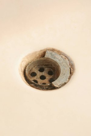 old broken and dirty bathroom sink drain mesh hole close-up, rusty limescale bath or tub drainage, cleaning repairing bathroom equipment concept, isolated background with copy space
