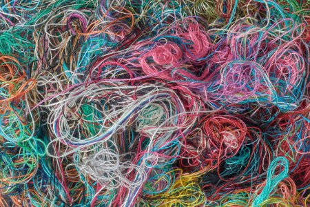 Foto de Pila de hilos de costura coloridos enredados textura de fondo, abstracto tomado de arriba en el marco completo - Imagen libre de derechos
