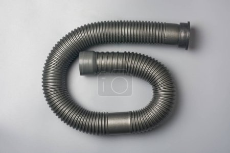 gewelltes flexibles Rohr oder Schlauch, Kunststoff oder PVC-Flexi-Rohr isolierten grauen Hintergrund, in Sanitärsystem für Wasserversorgung und Entwässerung verwendet