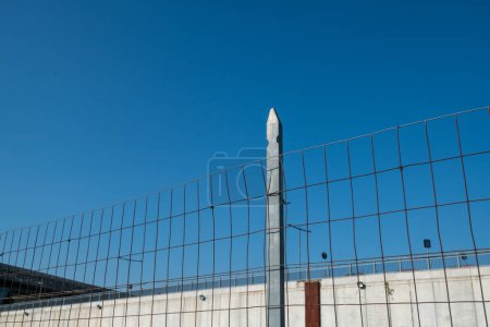 Photo for Post border with wire mesh. Galvanized posts, anonymous fence. borders with fences. protected area . - Royalty Free Image