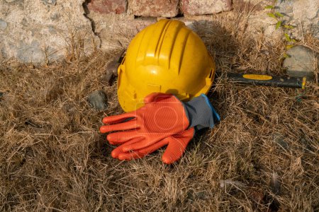 Arbeit auf Baustellen, individueller Schutz von Helm, Hammer und Handschuhen als Symbol der Arbeit, Zimmerleute und Werftarbeiter. PSA, persönliche Schutzausrüstung, schützt vor Unfällen und häufigen Verletzungen! Tischlersymbole.
