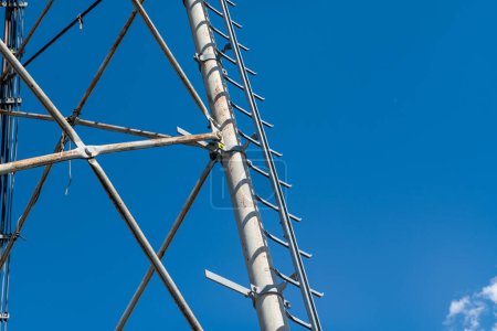 échelle technique pour treillis en acier galvanisé ancrée à la structure réticulaire d'une antenne de répéteur pour les bandes radio, téléphoniques et de communication. Cravates et écrous en acier inoxydable.