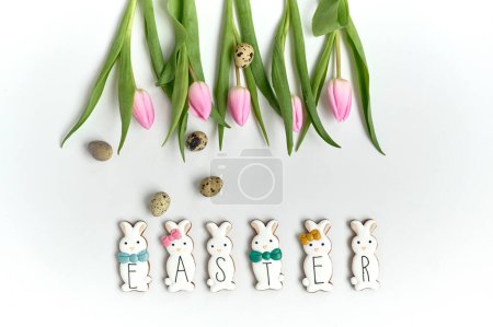 Téléchargez les photos : A chocolate bunny cookies with the quail eggs and tulips on a white background - en image libre de droit