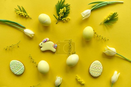Téléchargez les photos : Easter composition of yellow tulips, eggs and cookies on a yellow background - en image libre de droit