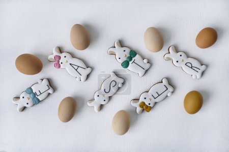 Téléchargez les photos : Oeufs de poulet avec des biscuits de lapin colorés sur fond blanc. vue de dessus. Concept de Pâques - en image libre de droit