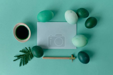 Téléchargez les photos : Stylo pour peindre des œufs et des œufs de couleur verte sur un fond vert - en image libre de droit