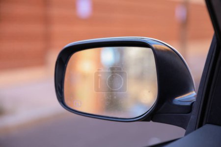 Téléchargez les photos : Miroir de voiture dans une photo de stock symbolise la réflexion, la perspective et la conscience. Il représente l'importance de regarder en arrière, d'être attentif à l'environnement et de tirer des enseignements des expériences passées. - en image libre de droit