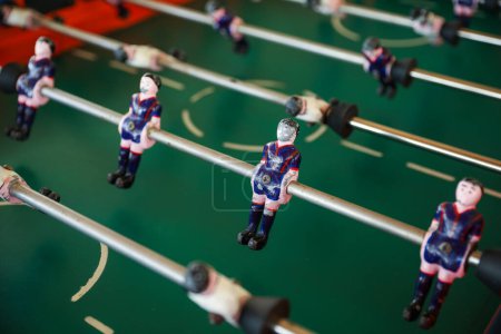 Photo for A foosball table is a recreational game symbolizing entertainment, skill, and socializing. It represents teamwork, competition, and the joy of play, and is often associated with bar and culture - Royalty Free Image