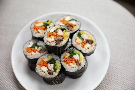 Photo for Kimbap is a traditional Korean dish made of rice, vegetables, and meat or seafood rolled in seaweed. It represents the country's rich culinary heritage and cultural diversity - Royalty Free Image