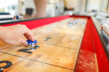 Photo for Shuffleboard is a game of precision and strategy, where players slide weighted discs down a narrow court to reach scoring areas. The sport represents the pursuit of accuracy and patience - Royalty Free Image