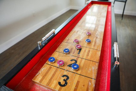 Foto de Shuffleboard es un juego de precisión y estrategia, donde los jugadores deslizan discos pesados por una pista estrecha para llegar a las áreas de puntuación. El deporte representa la búsqueda de la precisión y la paciencia - Imagen libre de derechos