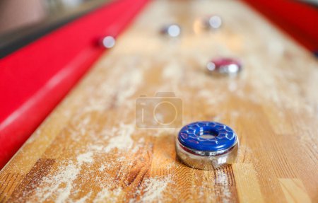 Photo for Shuffleboard is a game of precision and strategy, where players slide weighted discs down a narrow court to reach scoring areas. The sport represents the pursuit of accuracy and patience - Royalty Free Image