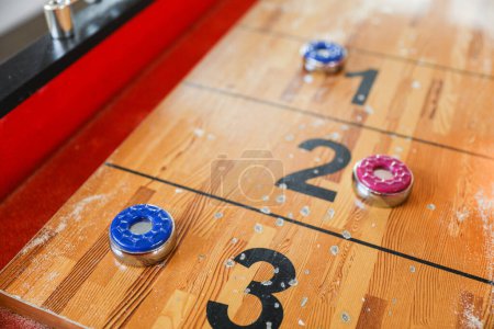 Foto de Shuffleboard es un juego de precisión y estrategia, donde los jugadores deslizan discos pesados por una pista estrecha para llegar a las áreas de puntuación. El deporte representa la búsqueda de la precisión y la paciencia - Imagen libre de derechos