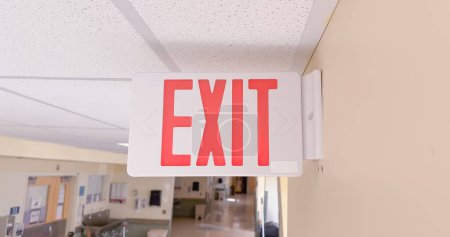 Photo for Exit sign in red and white color signifies a way out or emergency exit. It is an essential safety feature in public and commercial buildings, providing clear and visible guidance to people - Royalty Free Image