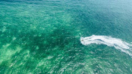 Téléchargez les photos : Vue aérienne de l'océan avec un jet ski et un bateau représente la joie de l'aventure et de l'exploration. L'immensité de la mer et la liberté de chevaucher les vagues - en image libre de droit