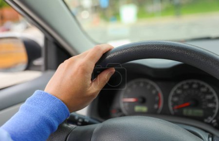 Photo for Hand on driving wheel symbolizes control, direction, and responsibility. It represents the power and freedom of mobility, as well as the need to be focused, alert, and responsible while driving - Royalty Free Image