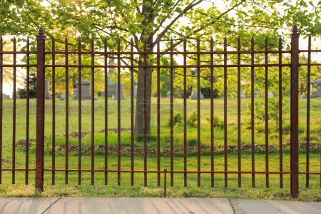 Photo for Black metal fence symbolizes boundaries, protection, and security. It represents the division between spaces, the need for privacy, and the sense of safety it provides - Royalty Free Image