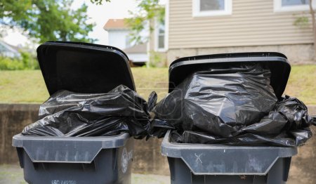 Los cubos de basura llenos de basura al aire libre significan desperdicio, limpieza, eliminación responsable y la necesidad de conciencia ambiental