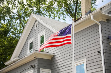 Foto de Bandera de EE.UU. fuera de la casa el 4 de julio y el Día de los Caídos simboliza el patriotismo, orgullo, unidad y recuerdo de los valores estadounidenses - Imagen libre de derechos