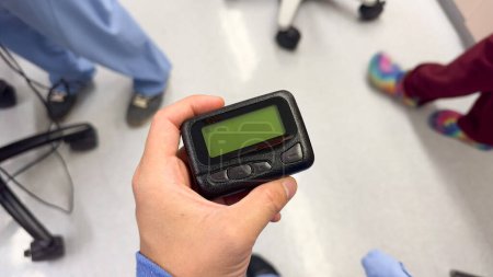 Photo for Beeper pager symbolizes communication, urgency, and efficiency in business and hospital settings. It represents the need for immediate response and coordination in professional environments - Royalty Free Image