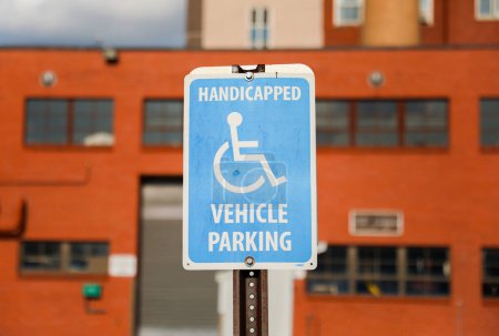 Photo for A blue and white wheelchair symbol on a signpost, representing accessibility and inclusivity for individuals with disabilities on the streets - Royalty Free Image