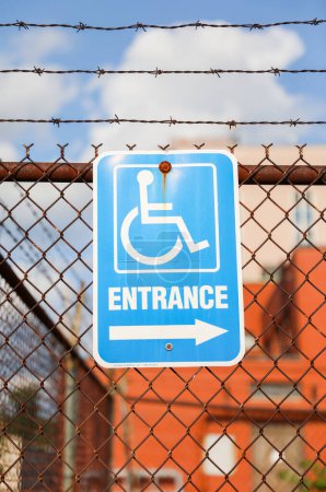 Foto de Un símbolo de silla de ruedas azul y blanca en un cartel, que representa la accesibilidad y la inclusividad para las personas con discapacidad en las calles - Imagen libre de derechos